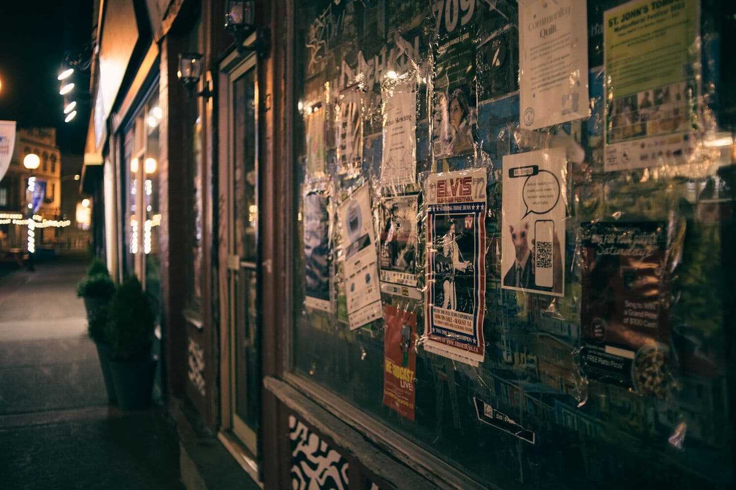 Affiches collées sur la vitrine d'une rue, de nuit