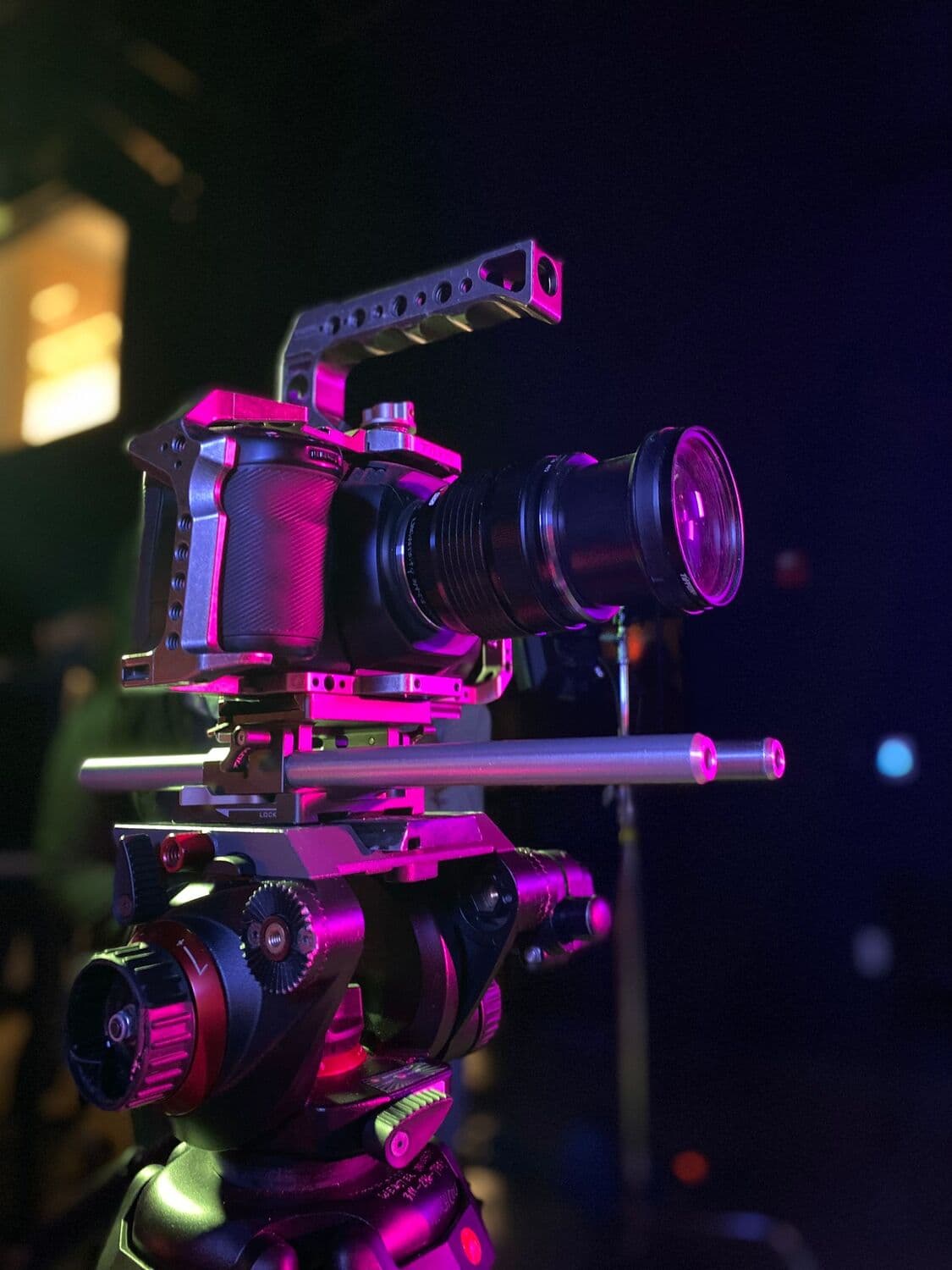 Caméra de cinéma sur trépied sous une lumière rose