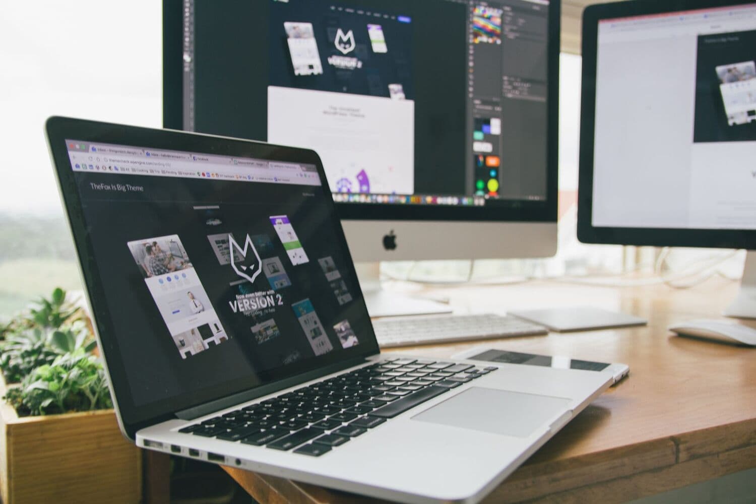 Poste de travail avec ordinateur portable et écrans affichant une interface de design